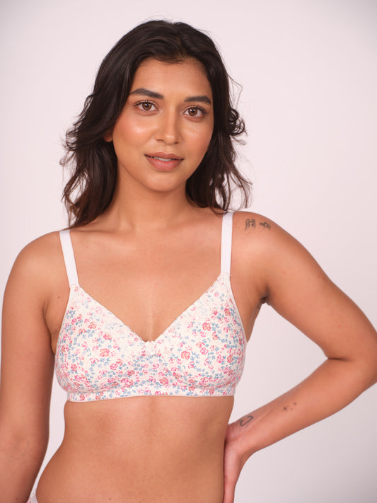 Woman wearing a floral bralette against a plain background