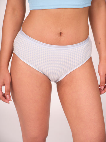 Person wearing light blue waffle-textured underwear on a plain background